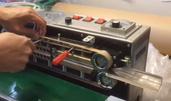 Continuous band sealer running on a brown PTFE Belt.