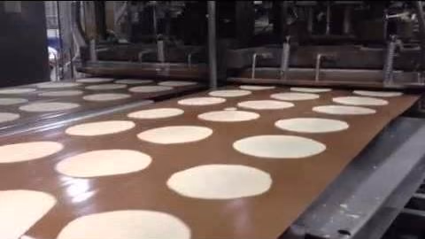 A conveyor belt faced with PTFE Cloth: product travels over the non-stick surface without bonding to it.